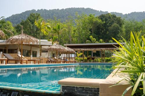 een groot zwembad met stoelen en parasols bij The Palm Villa in Ban Ai Dao