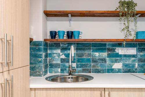 a kitchen with a sink and blue tiles at Loft de ensueño - Diseño abierto in Estepona