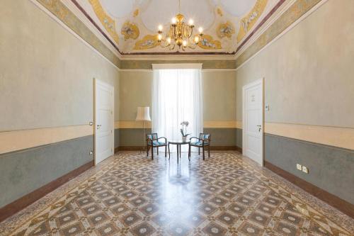 a room with a table and chairs and a chandelier at Palazzo Fasti in Casarano
