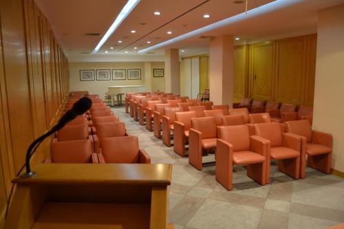a lecture hall with orange chairs and a microphone at Hotel Excelsior in Lanciano