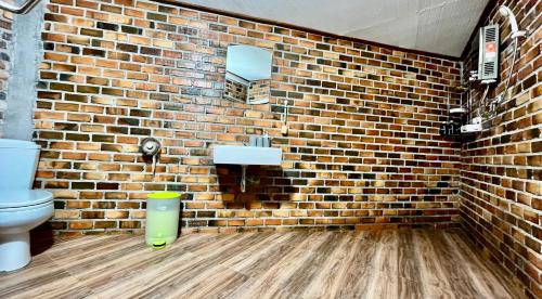 baño con aseo y pared de ladrillo en Starlight Beach Resort, en Ko Phayam