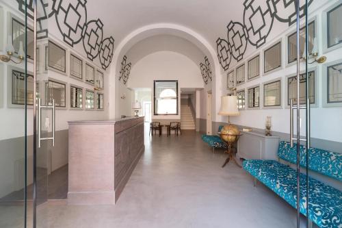 a lobby with blue chairs and a counter in a building at Palazzo Fasti in Casarano