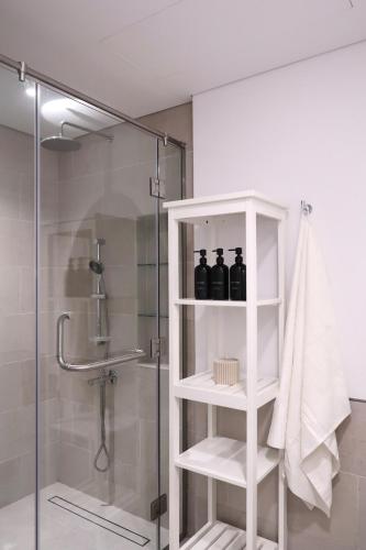 a bathroom with a shower with three bottles on a shelf at Burj View Apartment at Madinat Jumeirah Living in Dubai