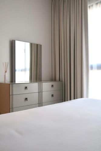 a bedroom with a bed and a dresser with a mirror at Burj View Apartment at Madinat Jumeirah Living in Dubai