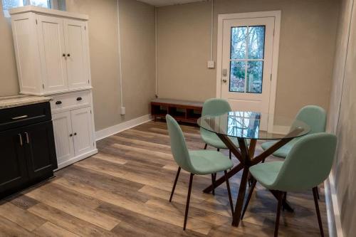 Un comedor con una mesa de cristal y sillas verdes. en Cozy Roanoke Retreat Quiet & Convenient Stay, en Ruxton