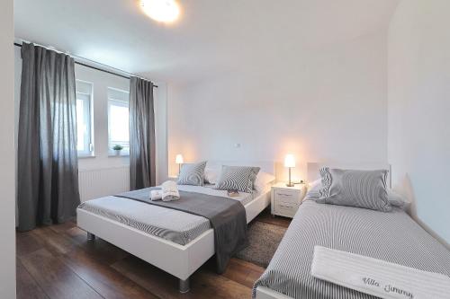 Un dormitorio con dos camas y una ventana. en Villa Stanic, en Seline