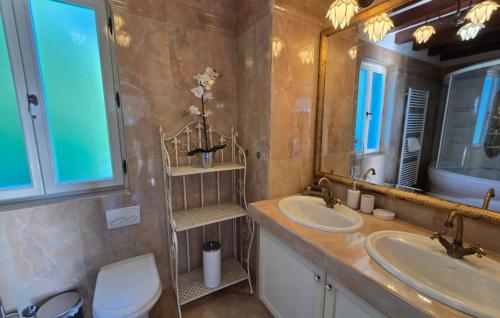 a bathroom with two sinks and a toilet and a mirror at Villa Palazzo del mar Opatija by Villas Guide in Mošćenička Draga