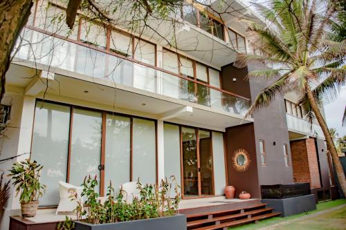 a building with large windows and a palm tree at Sundowners in Chilaw