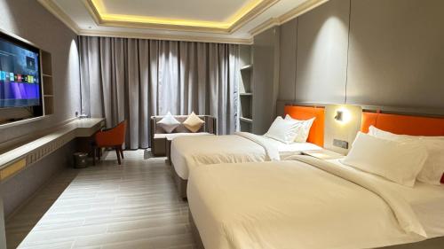 een hotelkamer met twee bedden en een flatscreen-tv bij Amaris Hotel in Barka