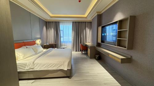 Una habitación de hotel con una cama y un televisor de pantalla plana. en Amaris Hotel, en Barka