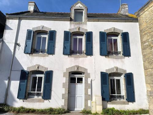 an old white house with blue shutters at Ancienne maison de pêcheur à St Cado charme, authenticité et confort in Belz