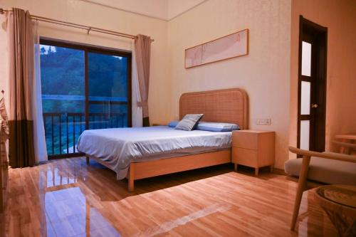 a bedroom with a bed and a large window at Shushushe B&B in Jiawan