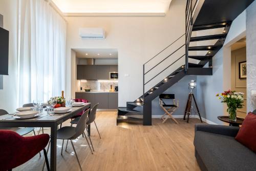 a living room with a dining table and a staircase at Cherubini Palace Thematic Apartment in Florence