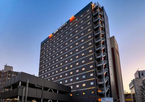 a tall building with a sign on the top of it at APA Hotel Morioka Ekimae in Morioka