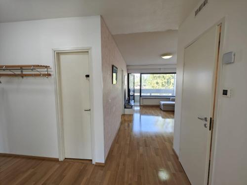an empty room with white walls and wood floors at Nice and cloce to the airport 75m2 app in Vantaa