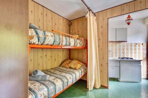 a bedroom with two bunk beds and a kitchen at Accogliente appartamento a due minuti dal centro in Morena