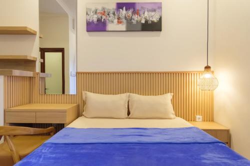 a bedroom with a bed with a blue blanket at TwoSpaces Living at Bunda Nana Residence, Gianyar in Gianyar