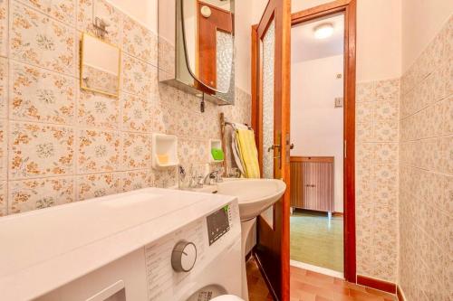 a bathroom with a sink and a washing machine at Accogliente appartamento a due minuti dal centro in Morena