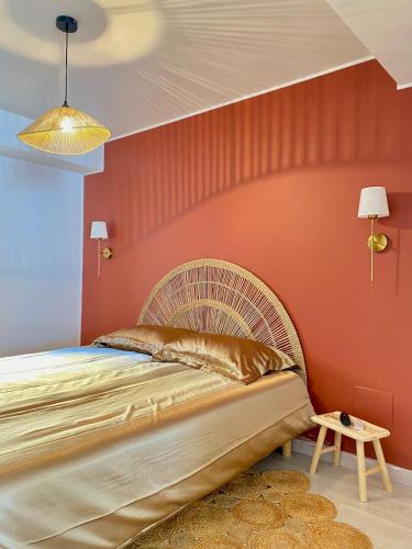 a bedroom with a bed and a red wall at L escapade dorée in Saulieu