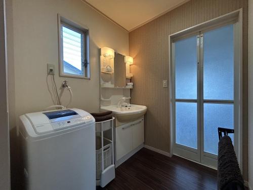 ein kleines Badezimmer mit Waschbecken und Toilette in der Unterkunft 南欧風のゴージャスなオーシャンビラ オーシャンビュー 1棟貸切 バーベキュー 長期滞在 ファミーユ伊豆高原 in Ito