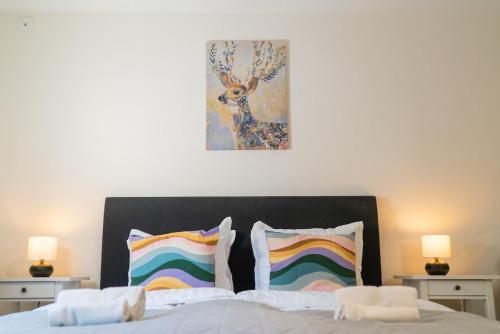 ein Schlafzimmer mit einem Bett und einem Gemälde an der Wand in der Unterkunft Rainbow Studio in Haga & Linné - Prime Location in Göteborg