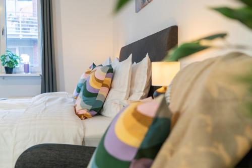 a bedroom with a bed with colorful pillows at Rainbow Studio in Haga & Linné - Prime Location in Gothenburg