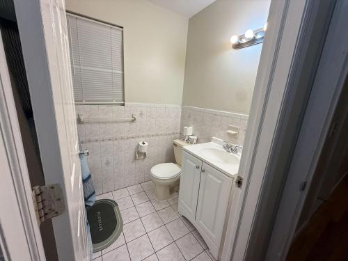 ein Badezimmer mit einer weißen Toilette und einem Waschbecken in der Unterkunft Urban haven 3 Kings bedroom near EWRNYC DTW in Newark