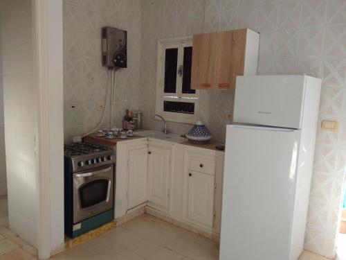a kitchen with a stove and a refrigerator at tagermess 1 in Midoun