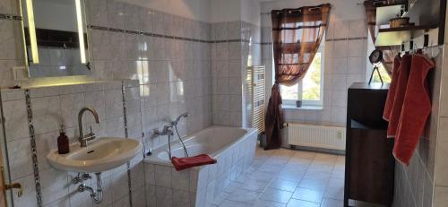 a bathroom with a sink and a bath tub at Pension & Café Am Krähenberg in Halle an der Saale