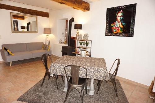 a living room with a table and chairs and a couch at La Ferme de la Bergerie 
