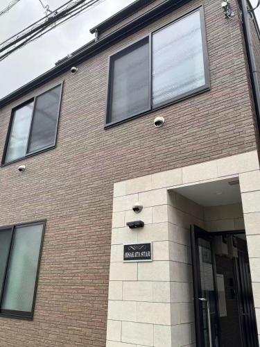 a brick building with a sign in front of it at 新宿区の新築木造アパート-駅から徒歩5分 in Tokyo