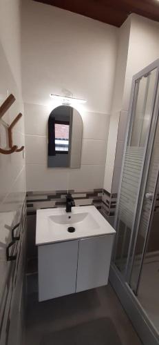 a white bathroom with a sink and a mirror at Au relais des ballons in Saint-Maurice-sur-Moselle