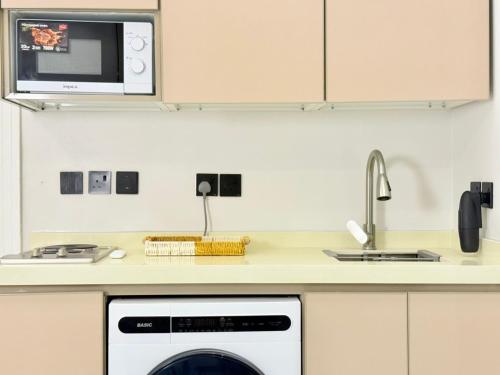 een keuken met een magnetron en een vaatwasser bij استديو بصالة طعام ومطبخ بجوار برج المملكة Tv 65 in Riyad