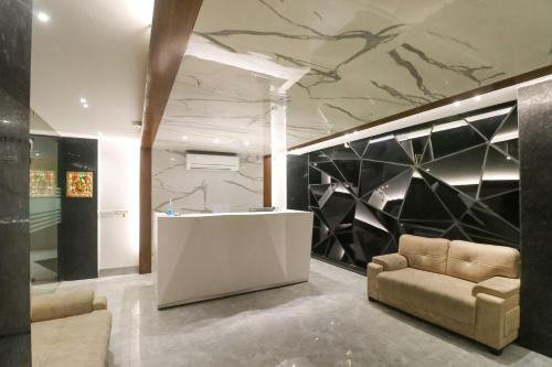 a lobby with a desk and a couch and a wall at Hotel O Lax in New Delhi
