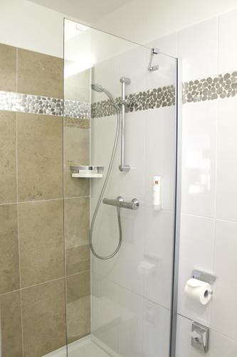 a shower stall with a glass door in a bathroom at Hotel Arena in Trnava