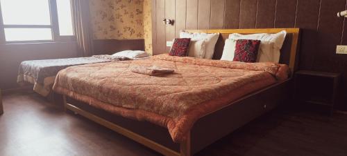 due letti in una camera d'albergo con un paravento di Assad Resorts a Srinagar
