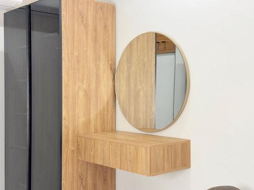 een spiegel aan een muur naast een houten plank bij استديو بصالة طعام ومطبخ بجوار برج المملكة Tv 65 in Riyad