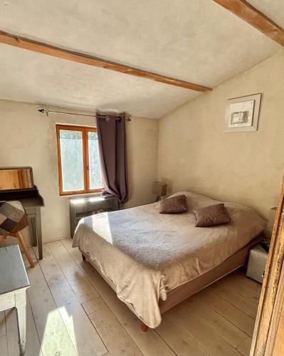 a bedroom with a large bed and a window at L'Oustaou des Monges in Mollans-sur-Ouvèze
