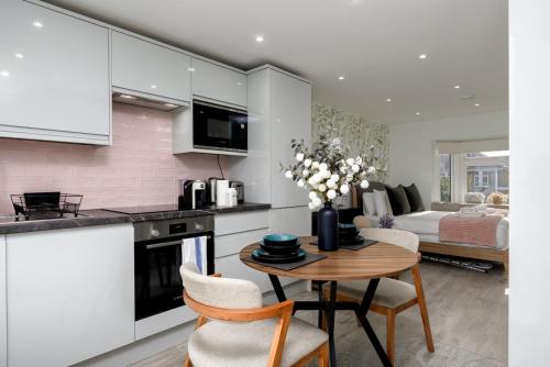 a kitchen and living room with a table and a bed at Greenford Apartments in Perivale