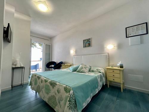 a bedroom with a bed and a desk and a window at Hotel Sant'Andrea in Marciana