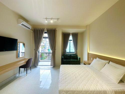 a hotel room with a bed and a chair and a desk at Vân Trang Hotel in Vĩnh Long