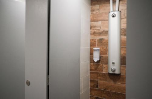 een badkamer met een douchecabine met een houten wand bij BodyGo Briançon in Briançon