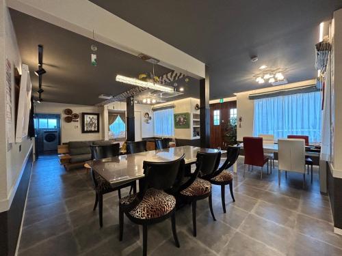 a dining room and living room with a table and chairs at アフリカンラグジュアリースタイルの豪華客室 1棟貸切 バーベキュー 大人数対応 ファミーユ大室 in Ito