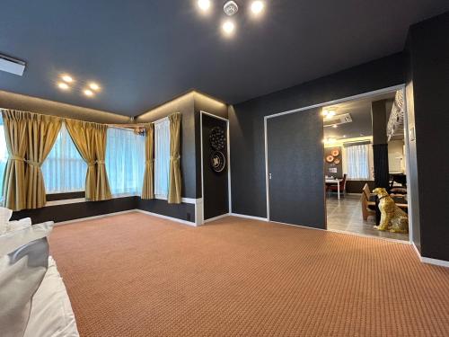 a large room with a bed and a living room at アフリカンラグジュアリースタイルの豪華客室 1棟貸切 バーベキュー 大人数対応 ファミーユ大室 in Ito