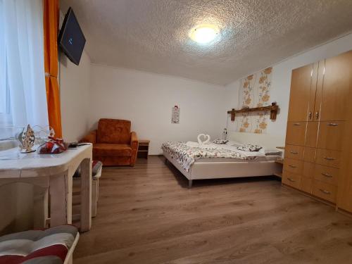 une chambre avec deux lits et une chaise dedans dans l'établissement Casa Farcaș Bușteni, à Buşteni