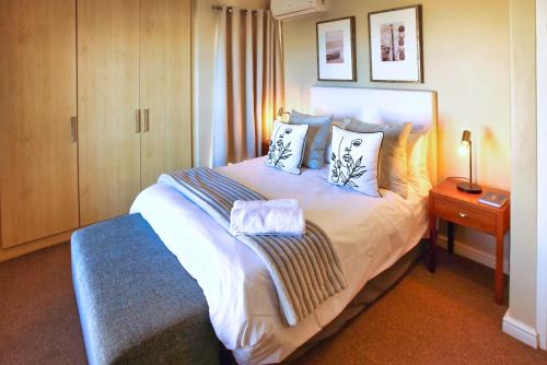 a bedroom with a large white bed with pillows at Ellefsen Golf Suite 108, Langebaan, 4-sleeper in Langebaan