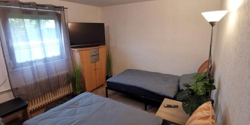 a small room with a bed and a tv at 4 Zimmer Ferienwohnung mit privater Küche, Bad und WC, mit Gratis Frühstück, Parkplätze und WiFi in Kassel