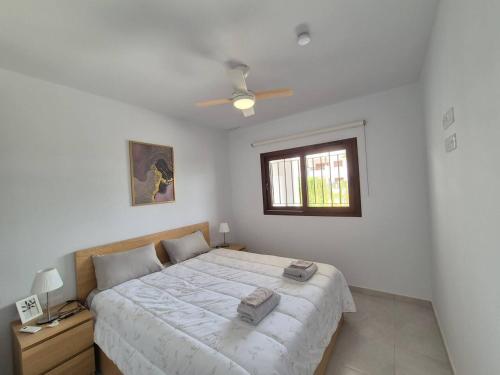 a white bedroom with a large bed and a window at Casa ariella 164 in San Juan de los Terreros