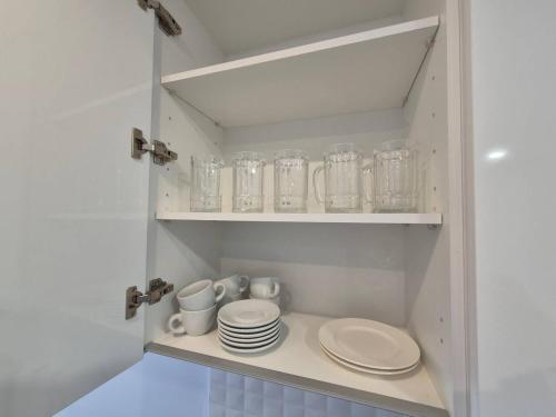 a cupboard with plates and mugs and glasses at Casa ariella 164 in San Juan de los Terreros