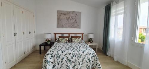 a bedroom with a bed and two tables with lamps at LORO PARQUE PUERTO DE LA CRUZ in Puerto de la Cruz